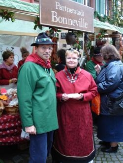 Ein Mann und eine Frau in typischer Bonneviller Tracht am Stand auf dem Staufener Weihnachtsmarkt