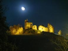Das Bild zeigt die beleuchtete Ruine der Burg Staufen mit dem Mond.